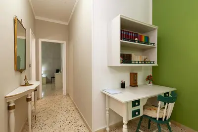 a home office with a desk and a green wall at Holiday Apartment My House in Palermo