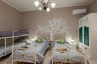 a bedroom with two beds and a tree mural on the wall at Holiday Apartment My House in Palermo