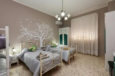 a bedroom with two beds and a tree mural at Holiday Apartment My House in Palermo