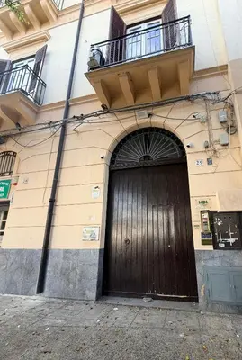 a building with a large wooden door on it at Palermo House 29-Central Station in Palermo
