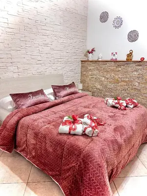 two stuffed animals are sitting on a red bed at Family house in Palermo