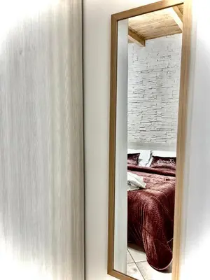 a mirror on a wall next to a bed at Family house in Palermo