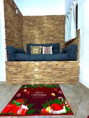 a blue couch with a merry christmas rug on the floor at Family house in Palermo