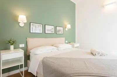 a bedroom with a white bed and a green wall at Donna Lia Apartment in Palermo