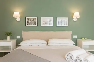 a bedroom with a bed with three pictures on the wall at Donna Lia Apartment in Palermo