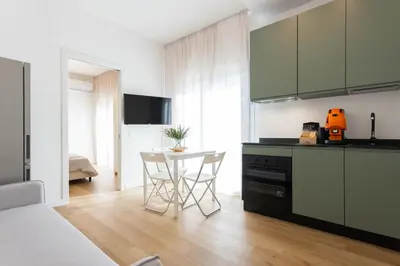 a kitchen with green cabinets and a table and chairs at Donna Lia Apartment in Palermo