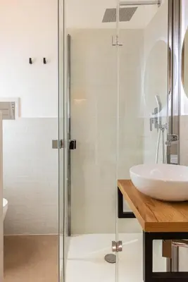 a bathroom with a glass shower and a sink at Donna Lia Apartment in Palermo