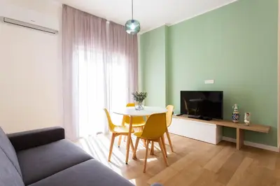 a living room with a couch and a table with chairs at Don Federico Apartment in Palermo