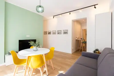 a living room with a table and yellow chairs at Don Federico Apartment in Palermo