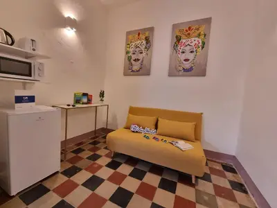 a living room with a couch and a kitchen at Donna Emma by Holiday World in Carini