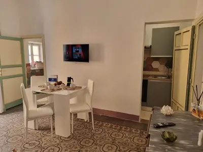a dining room with a table and chairs and a kitchen at Donna Emma by Holiday World in Carini