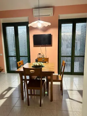 a dining room with a table and chairs and a television at Casa Vacanza Pinto a 80 mt dal mare in Campofelice di Roccella