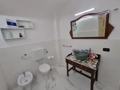 a bathroom with a sink and a toilet and a mirror at Donna Lidia by Holiday World in Carini