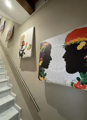 a hallway with paintings on the wall and stairs at Pesco Rooms Marineo in Marineo