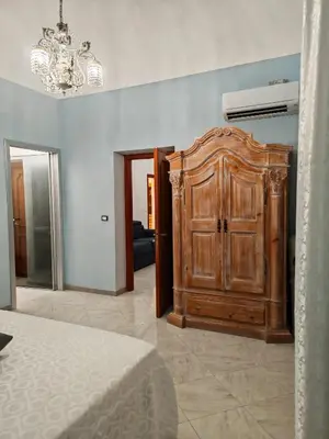 a bedroom with a wooden cabinet in a room at A casa di Adele in Castellammare del Golfo