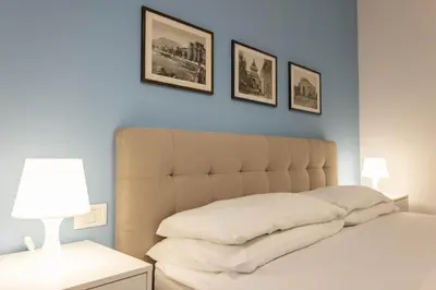 a bedroom with a bed with three pictures on the wall at Don Federico - For Couple in Palermo