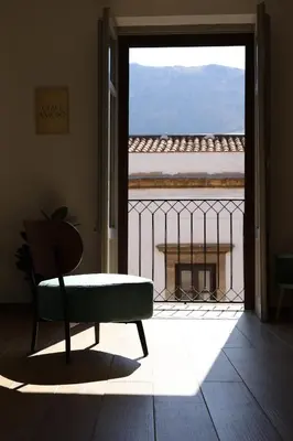 a room with a bench and a view of a balcony at Sikelìa Apartment in Carini