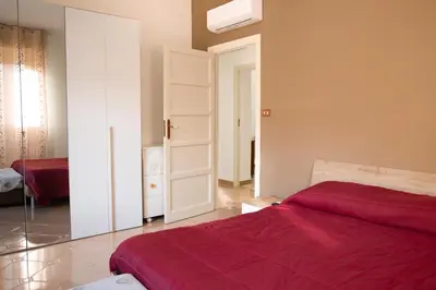 a bedroom with a red bed and a mirror at Ampio Appartamento con 3 Camere vicino la stazione - Re D'Aragona Vacanze in Termini Imerese