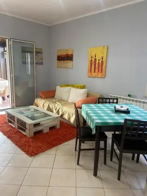 a living room with a table and a couch at La casa di Frank, con piscina privata in Campofelice di Roccella