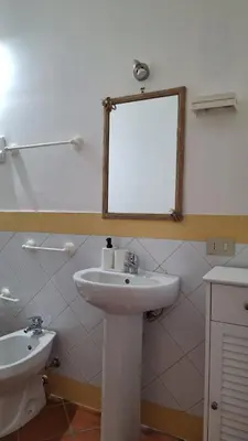 a bathroom with a white sink and a mirror at San Marco Rooms in Palermo