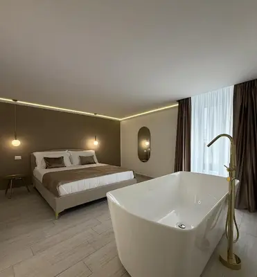 a bathroom with a bed and a tub in a room at Seraphia Apartment in Palermo