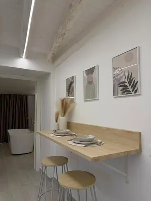 a kitchen with two stools and a table with plates at Seraphia Apartment in Palermo