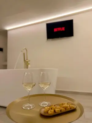 two glasses of wine and a plate of food on a table at Seraphia Apartment in Palermo