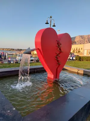 a red heart statue in a fountain in a park at La Finestra Sul Tirreno in Terrasini