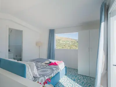 a bedroom with a bed and a large window at Villa Verde Essence in Castellammare del Golfo