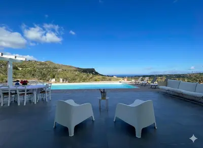a patio with a table and chairs and a pool at Villa Verde Essence in Castellammare del Golfo
