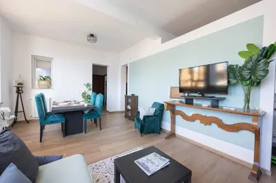 a living room with a television and a table with chairs at Taléa - Design Apartment a Palermo in Palermo