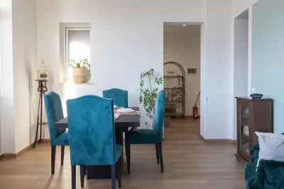 a dining room with a table and blue chairs at Taléa - Design Apartment a Palermo in Palermo
