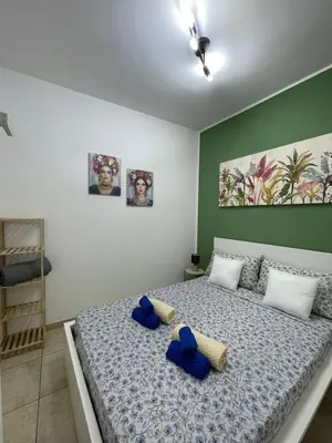 a bedroom with a bed with blue pillows on it at Sicilia Bedda Casa Vacanze in Lascari