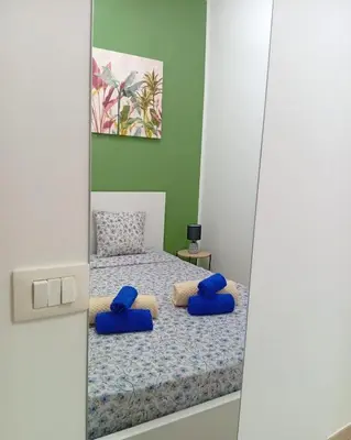 a bedroom with a bed with blue pillows on it at Sicilia Bedda Casa Vacanze in Lascari