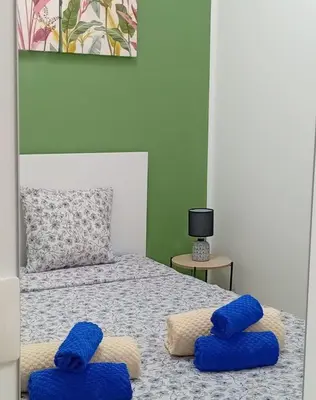 a bedroom with a bed with blue pillows on it at Sicilia Bedda Casa Vacanze in Lascari
