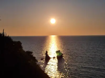 a person in a boat in the water at sunset at A casa dei nonni in Terrasini