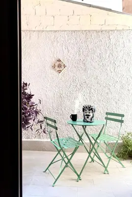 a table and chairs in a room with a wall at La Majolica Appartamento di design con terrazzino privato in centro in Palermo