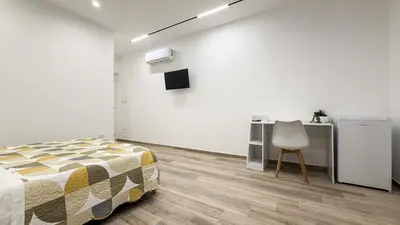 a bedroom with a bed and a desk and a chair at Street316 in Cinisi