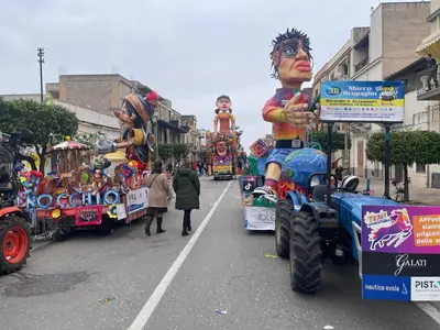 a group of parade floats on a city street at Street316 in Cinisi