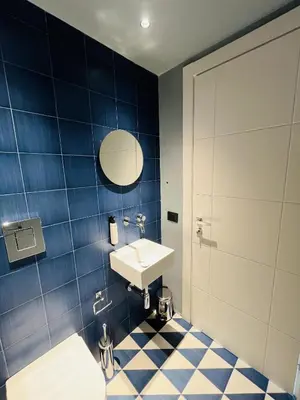 a bathroom with a sink and a blue tiled wall at Design Villa with private pool in Carini