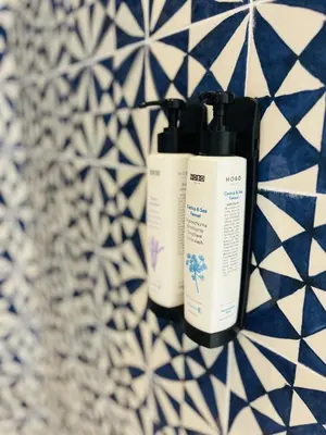 two bottles ofodorizers sitting on a blue and white tiles at Design Villa with private pool in Carini