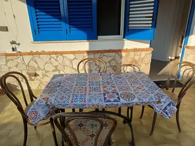 a table with chairs and a blue table cloth on it at Villa sul mare in Isola delle Femmine