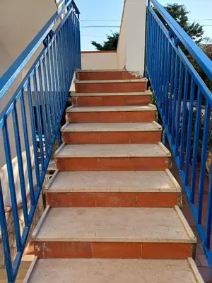 a set of stairs with blue metal railing at Villa sul mare in Isola delle Femmine