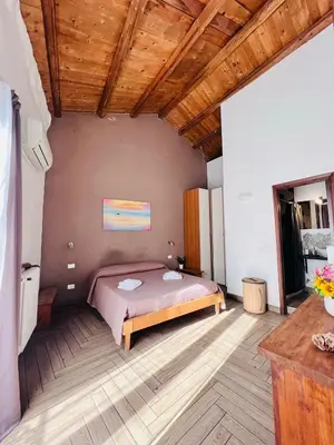 a bedroom with a bed and a wooden ceiling at Kasa Kaletta Rooms in Palermo