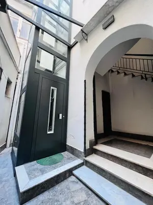 a black door on the side of a building with stairs at Kasa Kaletta Rooms in Palermo
