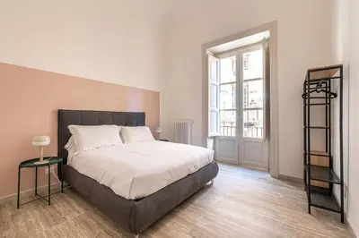a bedroom with a large bed and a window at Central City Apartment by Wonderful Italy in Palermo
