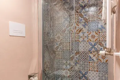 a bathroom with a shower with blue and white tiles at Central City Apartment by Wonderful Italy in Palermo