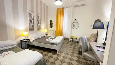 a hotel room with two beds and a couch at BB Essenze Club in Palermo
