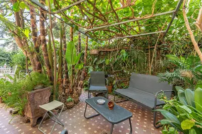 a patio with a bench and a table and trees at Un Giardino Segreto a Palermo by Wonderful Italy in Palermo