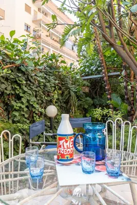 a glass table with a jug and glasses on it at Un Giardino Segreto a Palermo by Wonderful Italy in Palermo